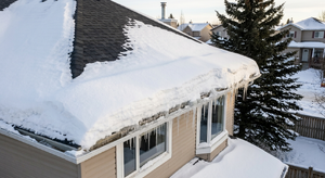 Heavy snow accumulation along roof eaves creating potential ice dam conditions