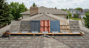 Roofing material samples side by side: asphalt shingles, metal panels, clay tile, slate, and wood shake